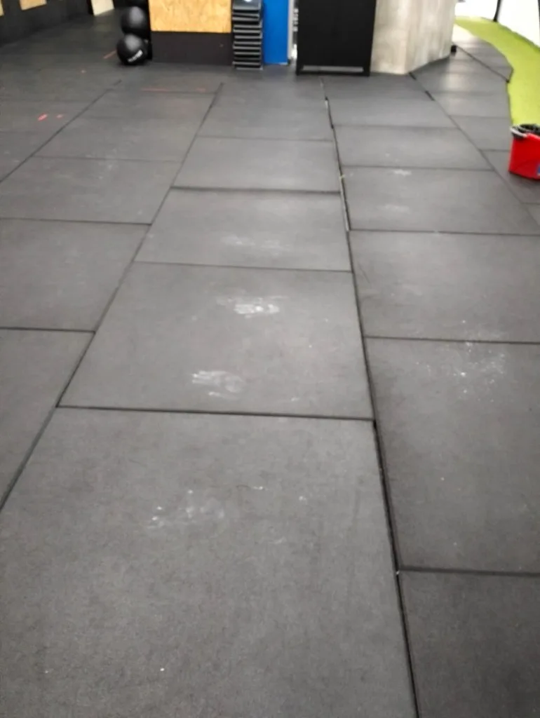 Suelo de gimnasio con marcas de tiza antes de la limpieza