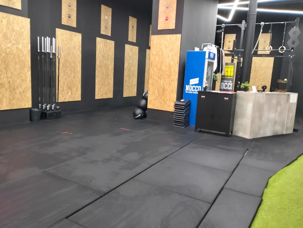 Sala de fitness amplia con suelo de caucho y equipamiento